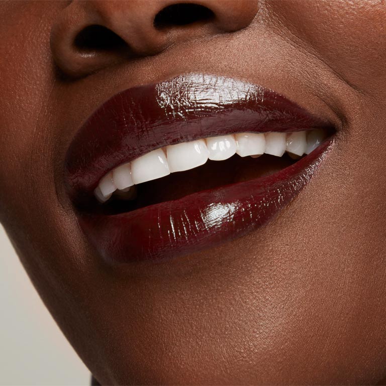 Up-close shot of woman's lips wearing deep shade of Mary Kay Supreme Hydrating Lipstick